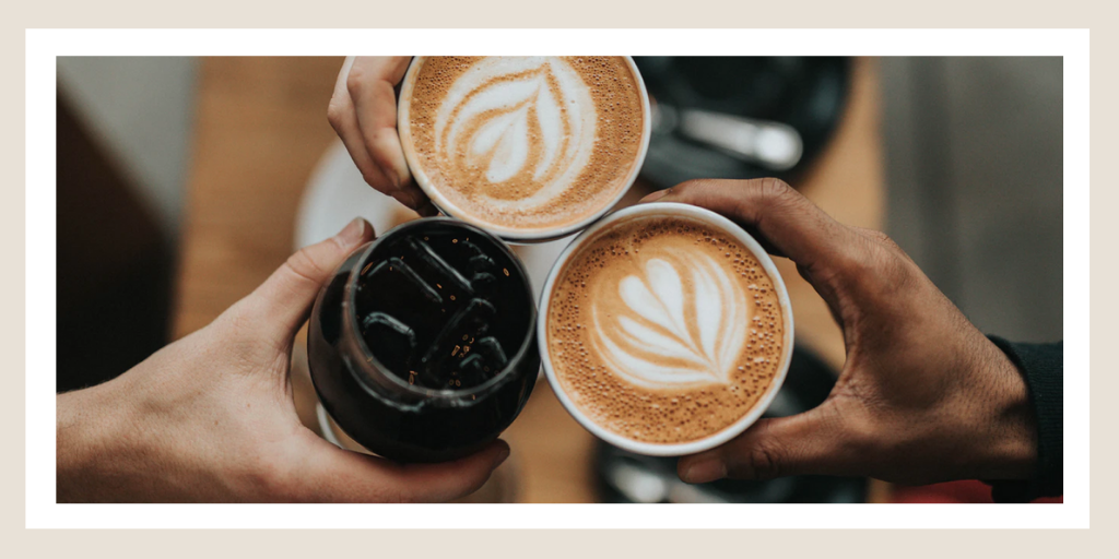 Three hands holding coffee cups