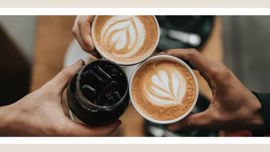 Three hands holding coffee cups